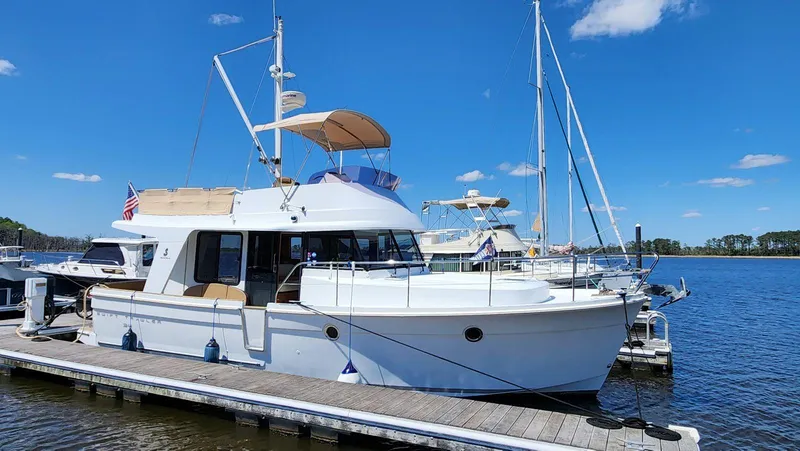 Slide: The Image of 2015 Beneteau Swift Trawler 34 docked on a sunny day, showcasing sleek design and spacious deck. - 3