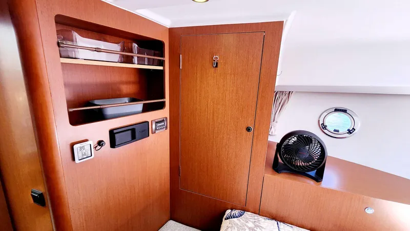 Slide: The Image of 2015 Beneteau Swift Trawler 34 interior with wooden cabinetry and a small fan. - 41