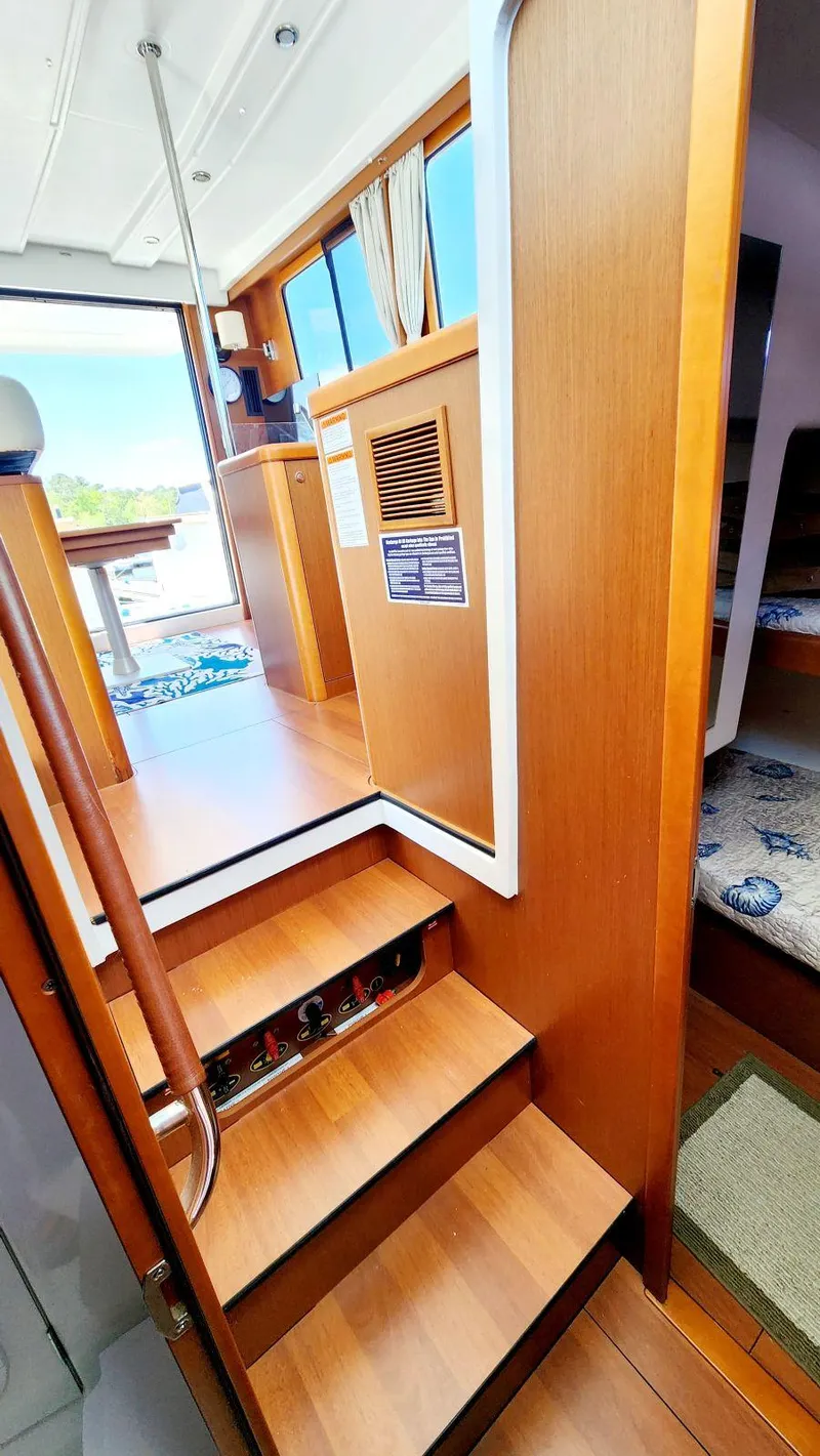 Slide: The Image of Interior of 2015 Beneteau Swift Trawler 34, featuring wooden stairs and cozy cabin space. - 46
