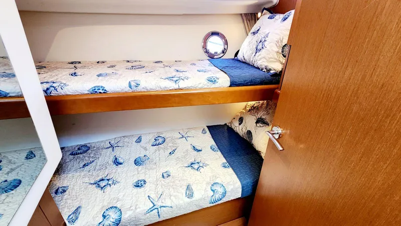 Slide: The Image of Bunk beds in 2015 Beneteau Swift Trawler 34 cabin with nautical-themed bedding. - 49