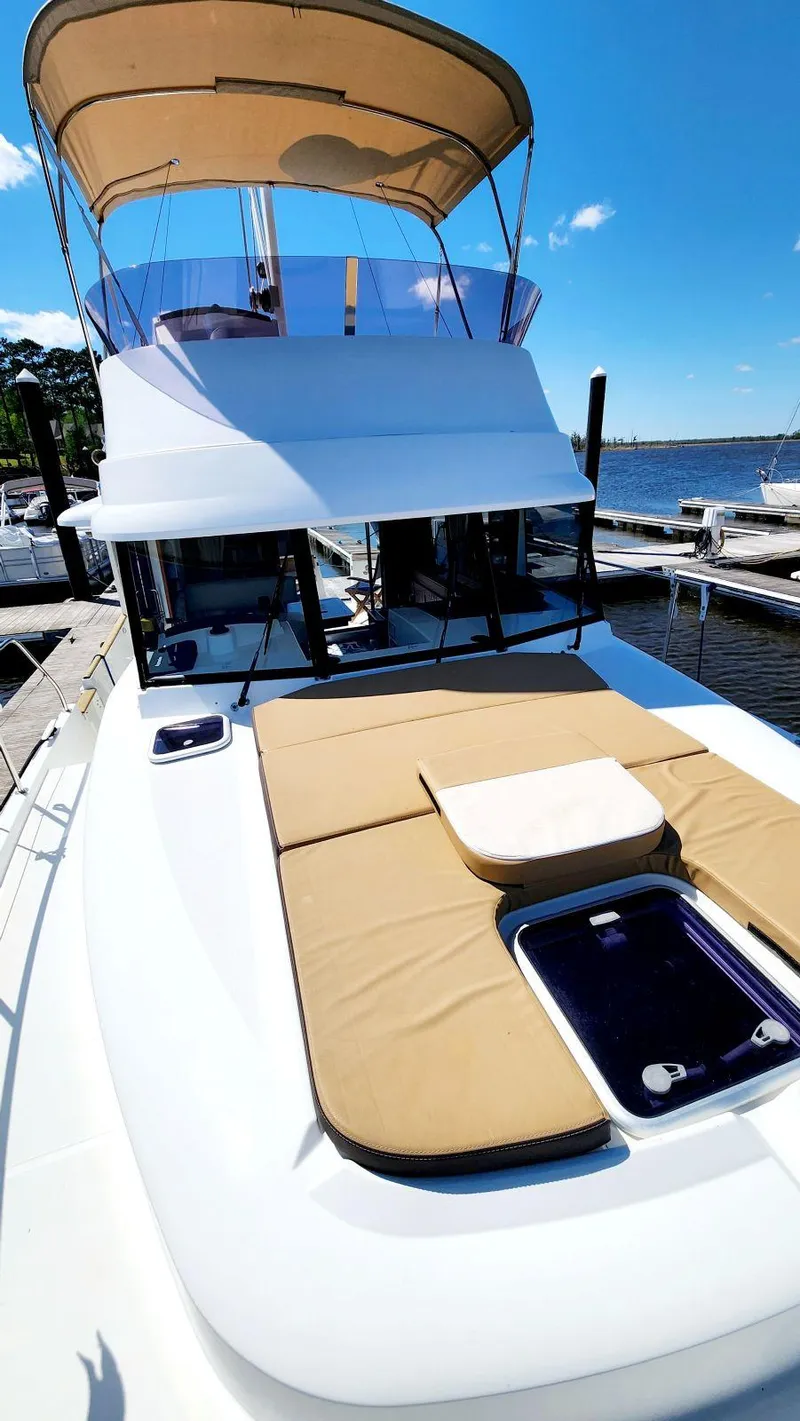Slide: The Image of 2015 Beneteau Swift Trawler 34 docked, featuring sun deck and flybridge under clear blue sky. - 8