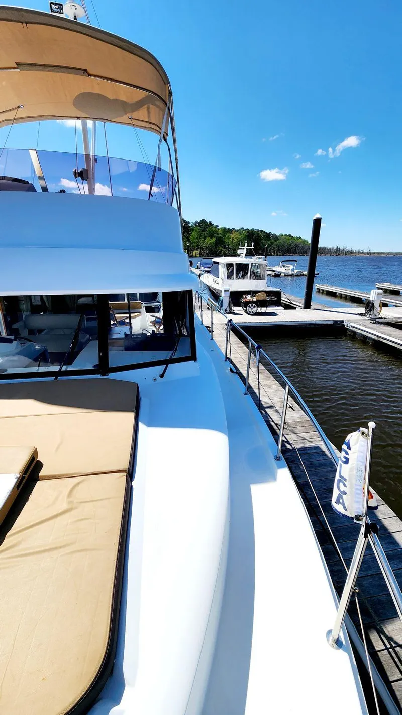 Slide: The Image of 2015 Beneteau Swift Trawler 34 docked, sunny day, clear blue sky, calm waters. - 9