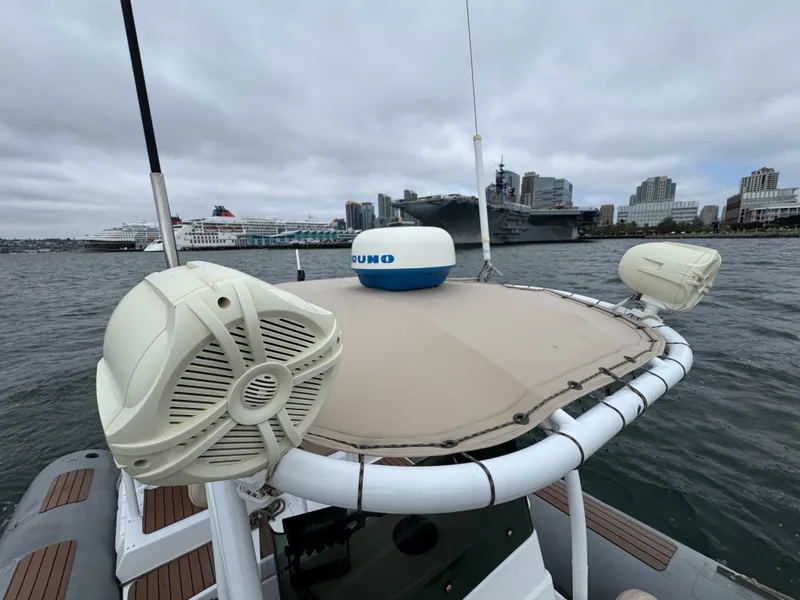 Slide: The Image of Nautica 33 Commercial RIB, 1995, on water with cityscape and ships in background. - 4