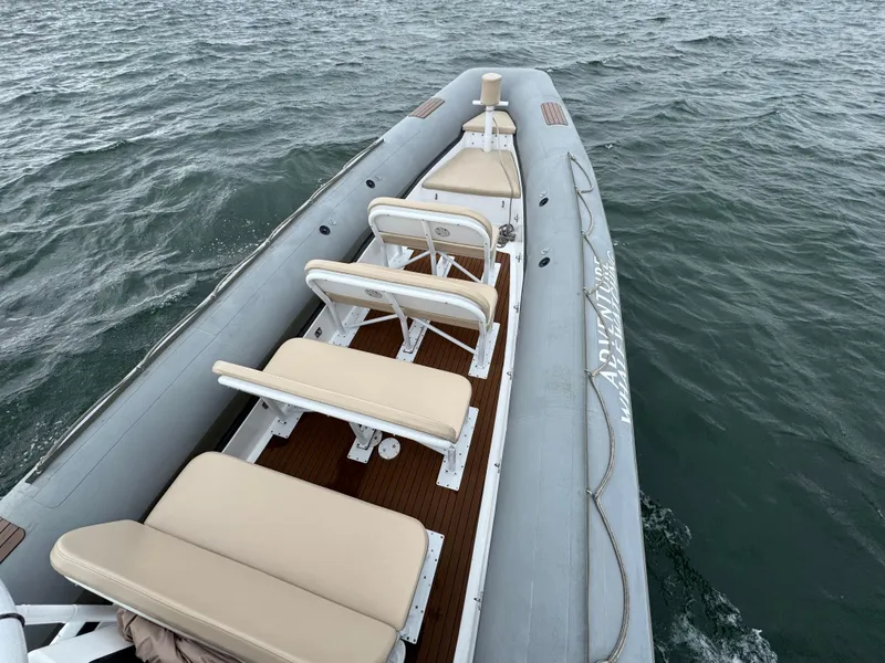 Slide: The Image of 1995 Nautica 33 Commercial RIB with beige seating on open water. - 5