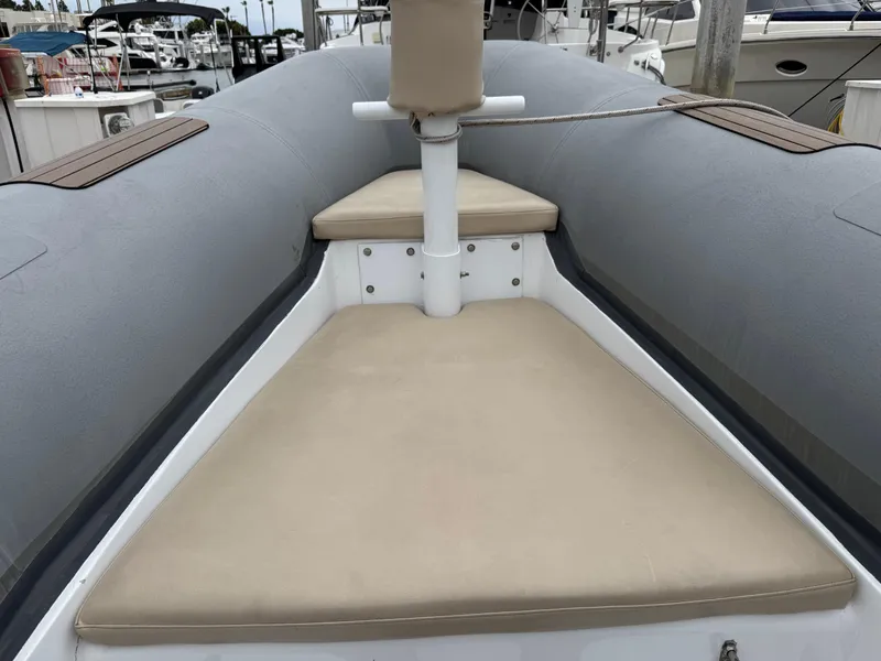 Slide: The Image of 1995 Nautica 33 Commercial RIB with beige seating, docked at a marina. - 6