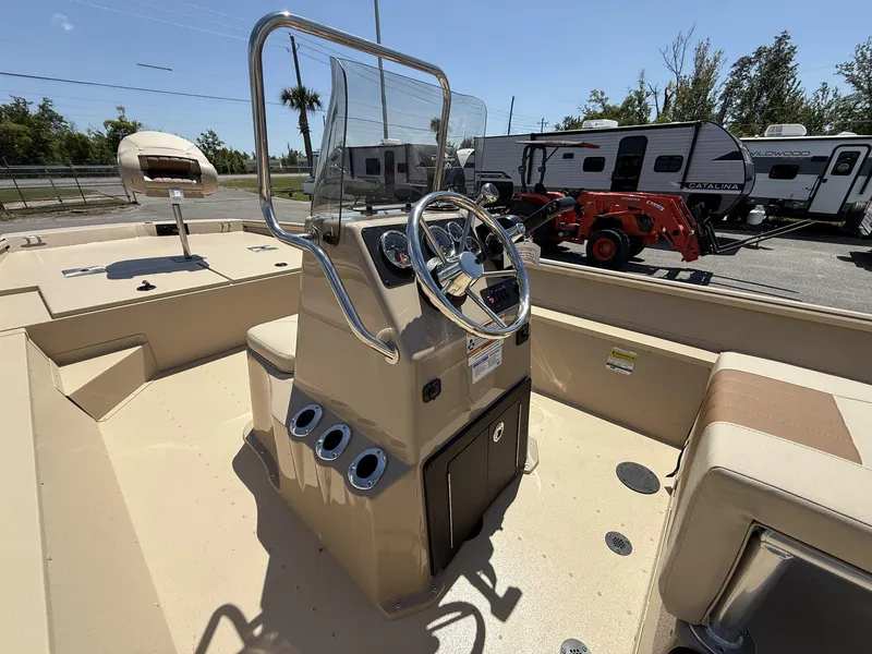 Slide: The Image of 2025 G3 Bay 20 boat interior with steering console and seating, parked near RVs and equipment. - 6
