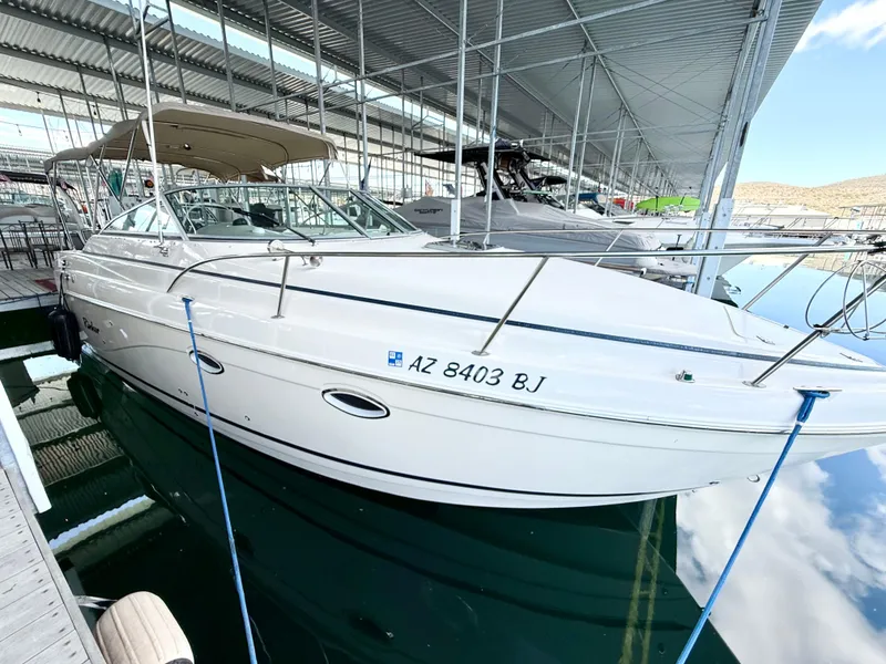 Slide: The Image of 2006 Rinker 270 Express Cruiser docked in a marina, side view. - 2