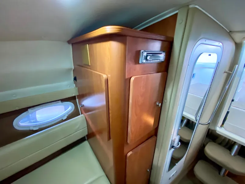 Slide: The Image of 2006 Rinker 270 Express Cruiser interior with wood cabinetry and seating area. - 20