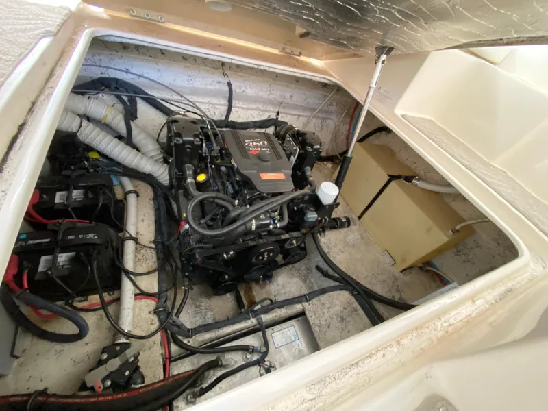 Slide: The Image of Engine compartment of a 2006 Rinker 270 Express Cruiser, showcasing mechanical components and wiring. - 23