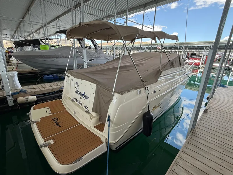 Slide: The Image of 2006 Rinker 270 Express Cruiser docked under a covered marina. - 28