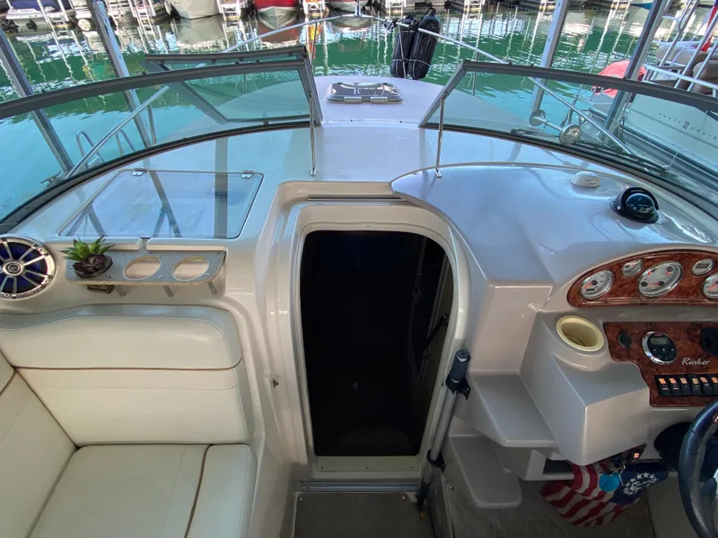 Slide: The Image of 2006 Rinker 270 Express Cruiser cockpit with helm, seating, and marina view. - 8
