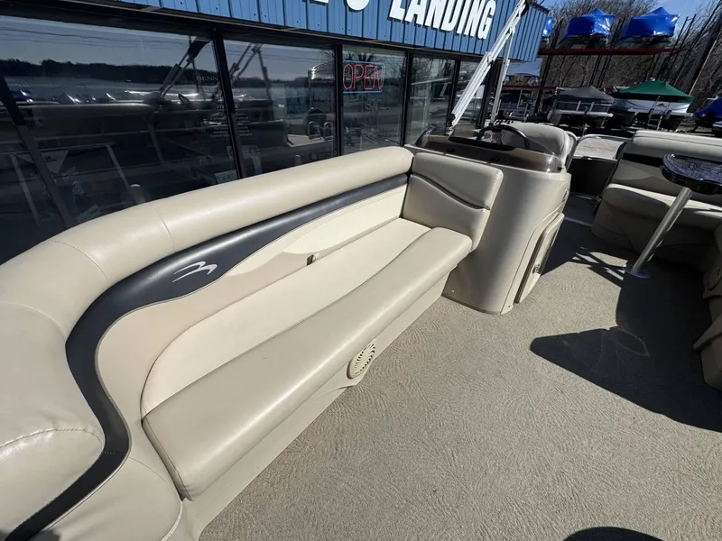 Slide: The Image of 2015 Bennington 20 SL pontoon boat with beige seating, docked near a marina. - 7
