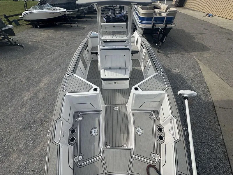 Slide: The Image of 2023 Yamaha Boats 220 FSH Sport, sleek design, spacious deck, parked outdoors. - 2