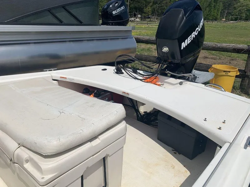 Slide: The Image of 2012 Mako PRO 17 SKIFF boat with Mercury outboard motor, white seating, and storage area. - 5