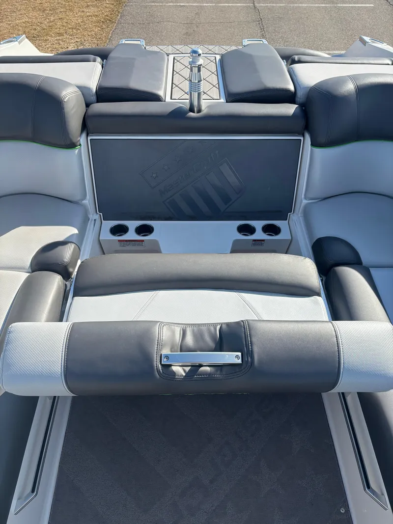 Slide: The Image of 2015 MasterCraft X23 boat interior with cushioned seating and cup holders. - 14