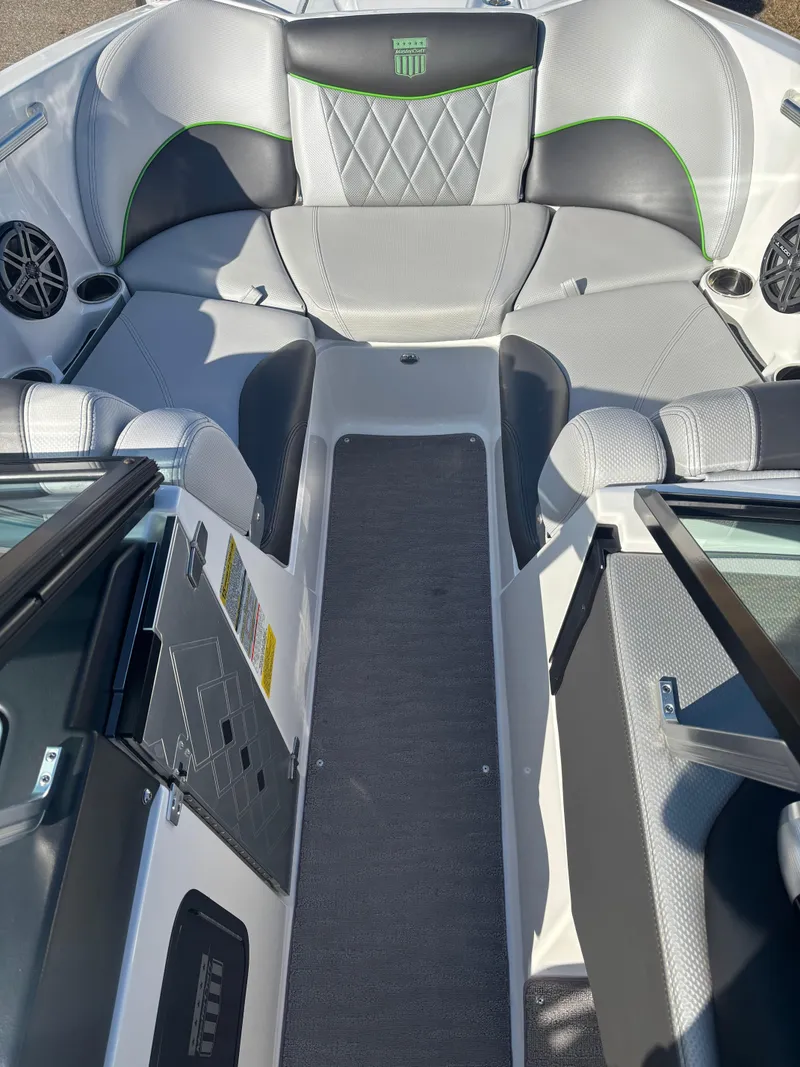 Slide: The Image of 2015 MasterCraft X23 boat interior with gray seating and green accents. - 16
