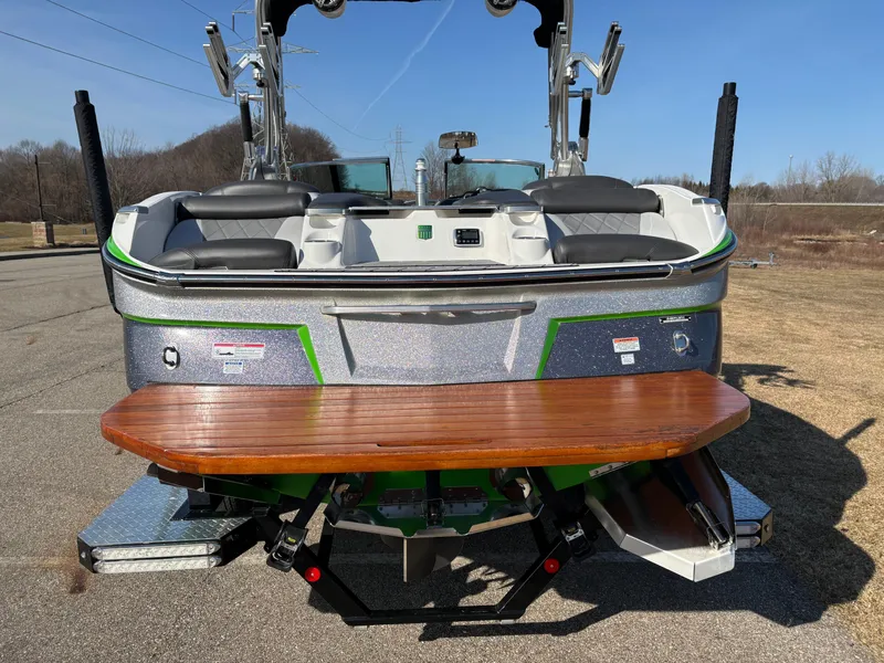 Slide: The Image of 2015 MasterCraft X23 boat with wooden swim platform, parked on a sunny day. - 19
