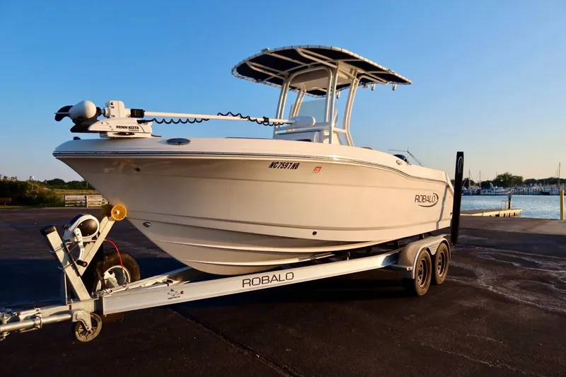 The Image of 2023 Robalo R200 Center Console boat on trailer, parked near waterfront. - 1