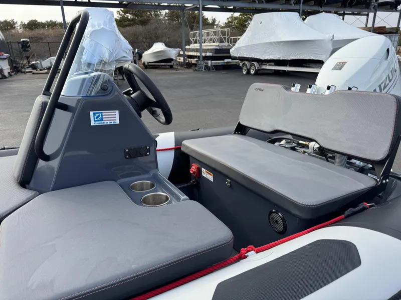 Slide: The Image of 2023 Zodiac Open 4.2 boat interior with seating and steering wheel in a marina setting. - 10