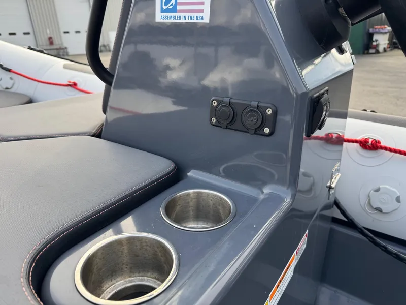 Slide: The Image of 2023 Zodiac Open 4.2 boat console with cup holders and power outlets. - 13