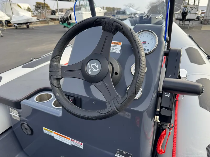 Slide: The Image of 2023 Zodiac Open 4.2 boat dashboard with steering wheel and gauges. - 15