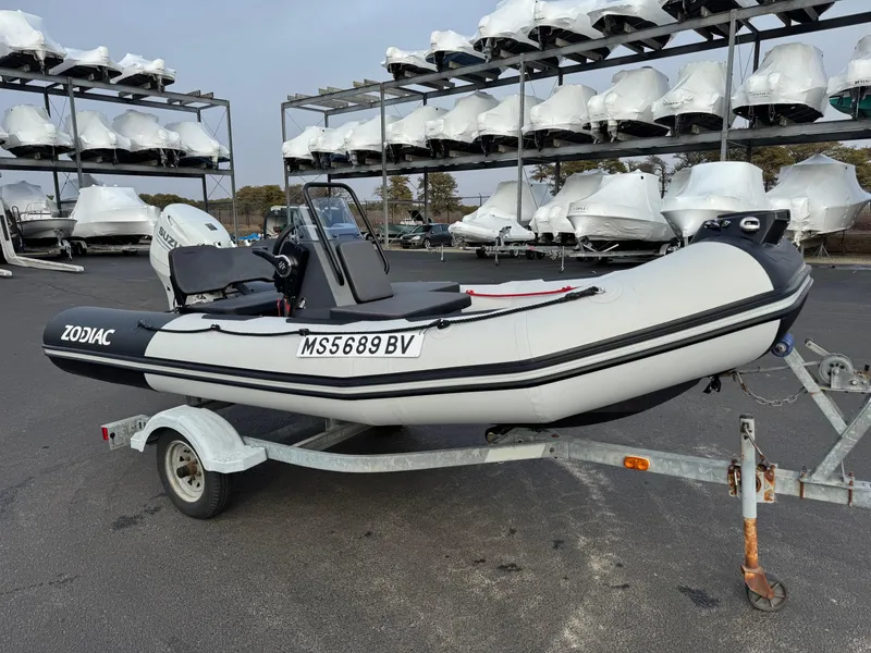 Slide: The Image of 2023 Zodiac Open 4.2 inflatable boat on trailer, parked in marina storage area. - 3
