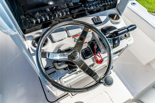 Slide: The Image of Person organizing storage on 2022 Blue Wave 2800 Makaira boat, near scenic shoreline. - 16