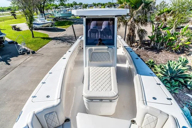 Slide: The Image of 2022 Blue Wave 2800 Makaira boat cruising on open water, showcasing spacious deck and powerful engine. - 21