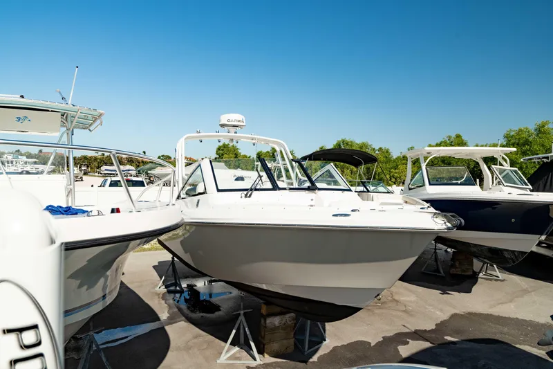 Slide: The Image of 2016 Everglades 230 Dual Console boat displayed outdoors under clear blue sky. - 12