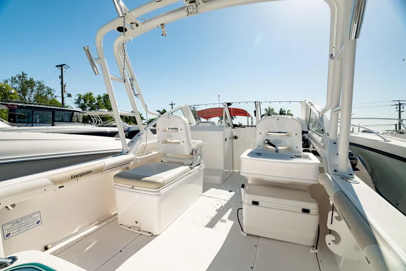 Slide: The Image of 2016 Everglades 230 Dual Console boat interior with seating and storage under clear blue sky. - 14