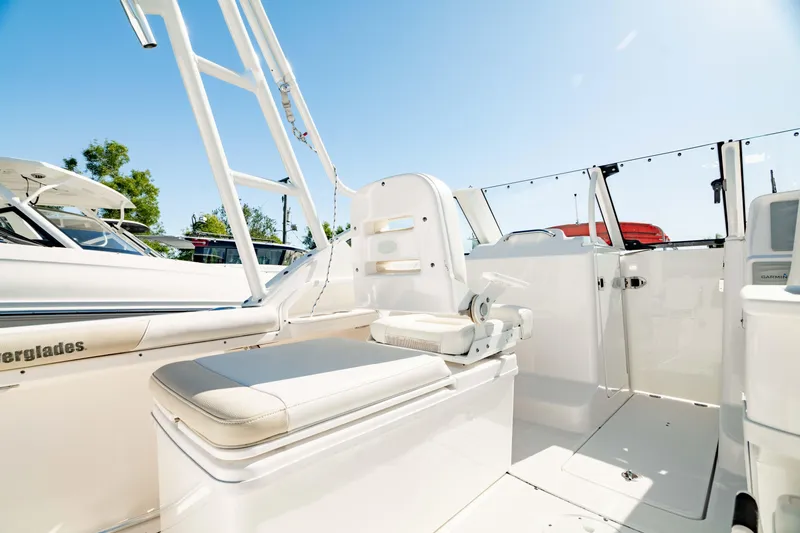 Slide: The Image of 2016 Everglades 230 Dual Console boat interior with seating and clear blue sky. - 18