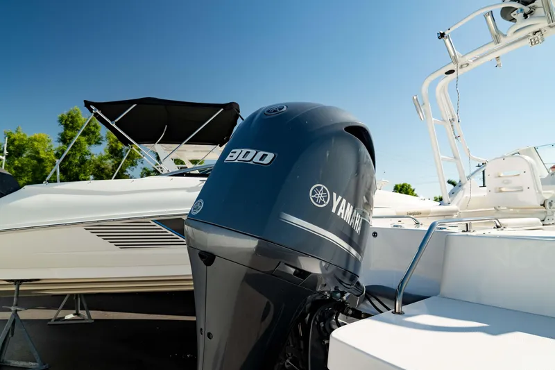 Slide: The Image of 2016 Everglades 230 Dual Console boat with Yamaha 300 engine, docked under clear blue sky. - 2