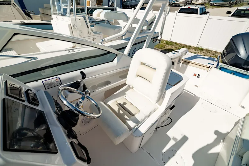 Slide: The Image of 2016 Everglades 230 Dual Console boat interior with steering wheel and seating. - 21