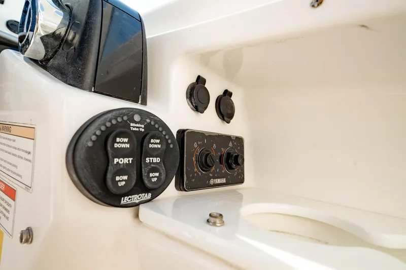 Slide: The Image of Control panel on 2016 Everglades 230 Dual Console boat, featuring trim tab buttons. - 22