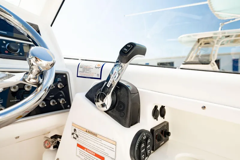 Slide: The Image of Control panel of 2016 Everglades 230 Dual Console boat, featuring steering wheel and throttle lever. - 24