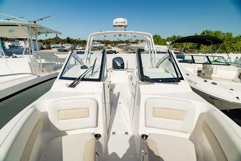 Slide: The Image of 2016 Everglades 230 Dual Console boat with open seating and clear skies in a marina. - 34