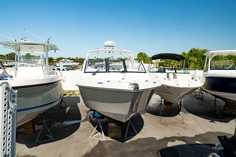 Slide: The Image of 2016 Everglades 230 Dual Console boat displayed outdoors among other boats. - 9