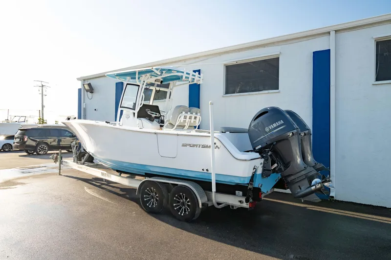 Slide: The Image of 2020 Sportsman Heritage 251 Center Console boat on trailer, parked near a building. - 10