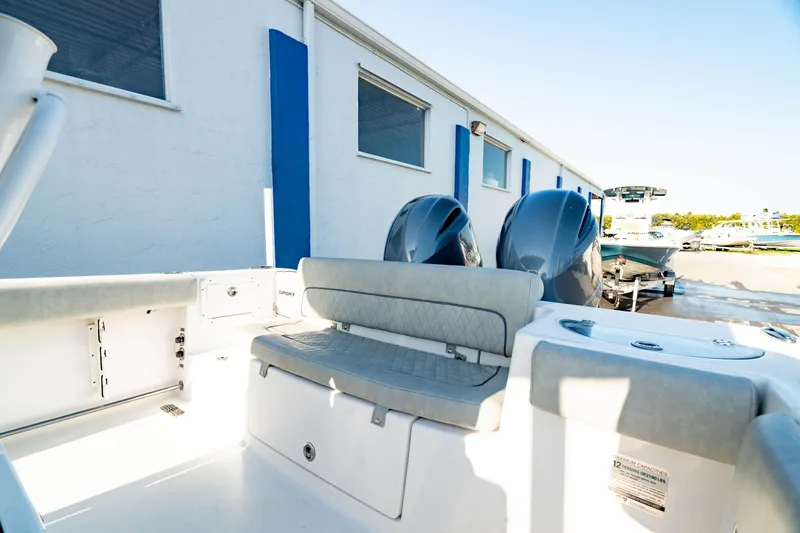 Slide: The Image of 2020 Sportsman Heritage 251 Center Console boat with dual engines, docked near a building. - 11