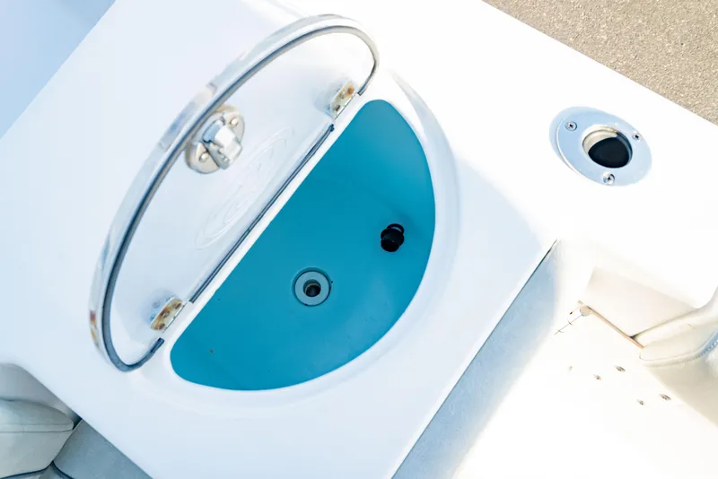 Slide: The Image of 2020 Sportsman Heritage 251 Center Console livewell with open lid and blue interior. - 13