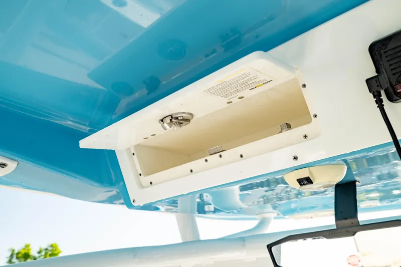 Slide: The Image of 2020 Sportsman Heritage 251 Center Console storage compartment, open and empty, with blue and white interior. - 26