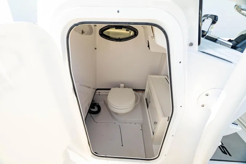 Slide: The Image of 2020 Sportsman Heritage 251 Center Console boat interior with compact marine toilet. - 28