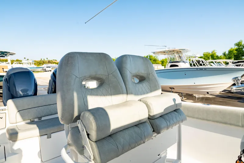 Slide: The Image of 2020 Sportsman Heritage 251 Center Console boat with comfortable seating, docked under clear skies. - 3