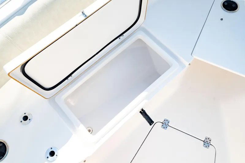 Slide: The Image of 2020 Sportsman Heritage 251 Center Console boat storage compartment open. - 34