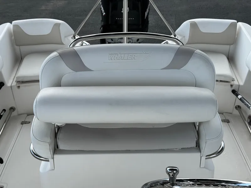 Slide: The Image of 2006 Boston Whaler 210 Outrage boat interior with white seating and steering console. - 13
