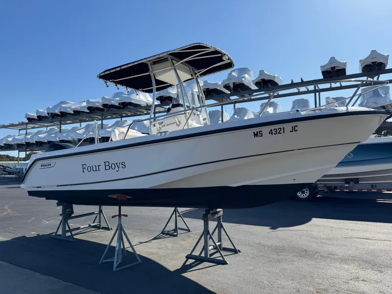 Slide: The Image of 2006 Boston Whaler 210 Outrage boat on stands, named "Four Boys," in a storage facility. - 3