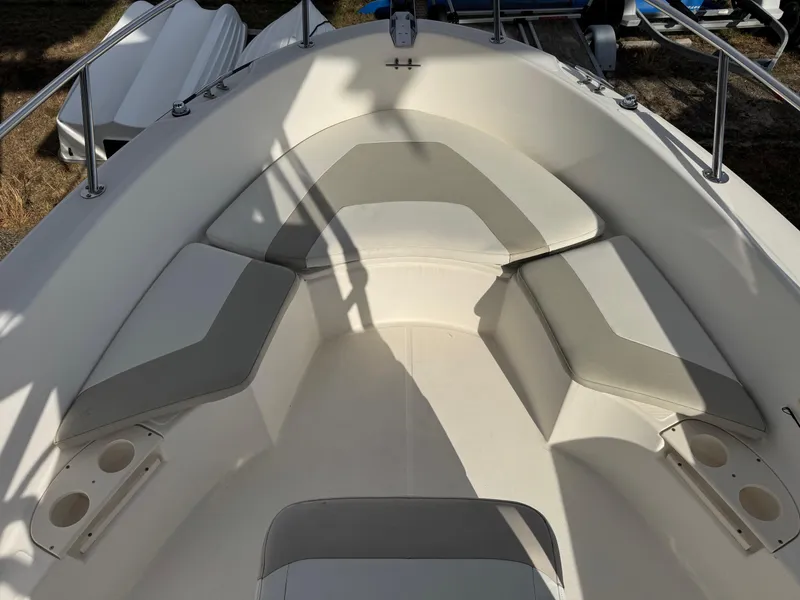 Slide: The Image of 2006 Boston Whaler 210 Outrage boat interior with cushioned seating and cup holders. - 9