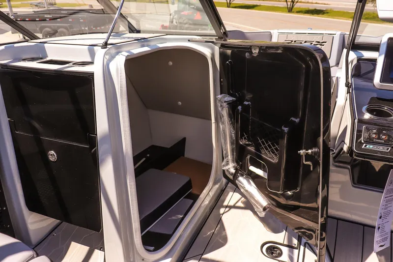 Slide: The Image of 2024 Yamaha Boats 255XD interior cabin with open door, showcasing sleek design and storage space. - 26