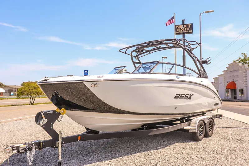 Slide: The Image of 2024 Yamaha Boats 255XD on trailer, parked outdoors under clear blue sky. - 5