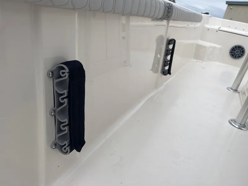 Slide: The Image of 2025 Carolina Skiff 21 LS boat interior with rod holders and cushioned rail. - 12